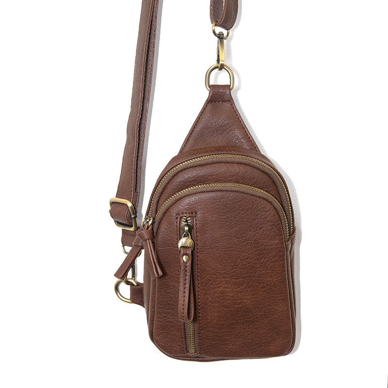 A brown sling bag with a zipper closure, a detachable strap, and brass plated hardware.